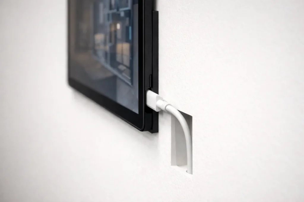 Dettaglio montaggio tablet a muro senza cavi visibili per dashboard domotica.